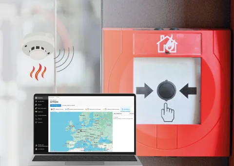 Bild von einer Brandmeldeanlage und einem Laptop, auf dem das Fernwartungssystem zu sehen ist.