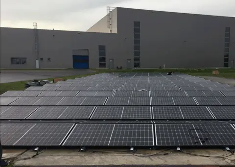 PV Anlage auf einer Freifläche vor einer Industriehalle
