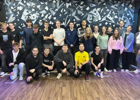 Eine Gruppe von Auszubildenden steht nebeneinander und posiert für ein Gruppenfoto