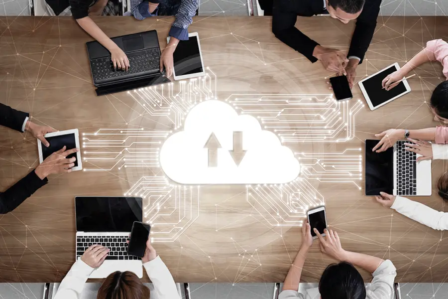 Mitarbeiter in einer Besprechung greifen auf Daten über eine Cloud zu.