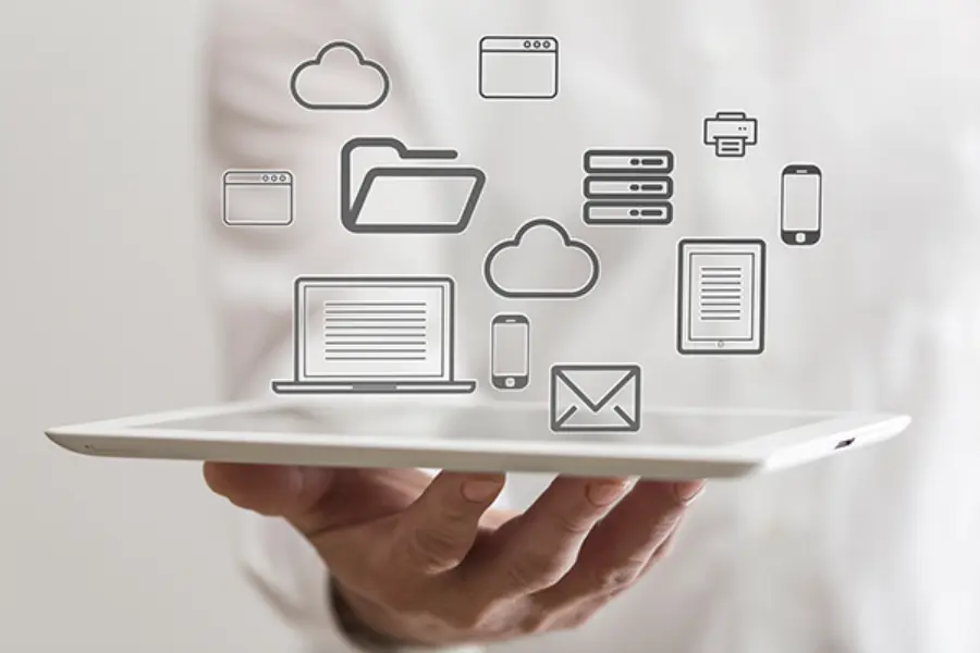 Ein Mann hält ein Ipad auf dem verschiedene Technik-Icons schweben