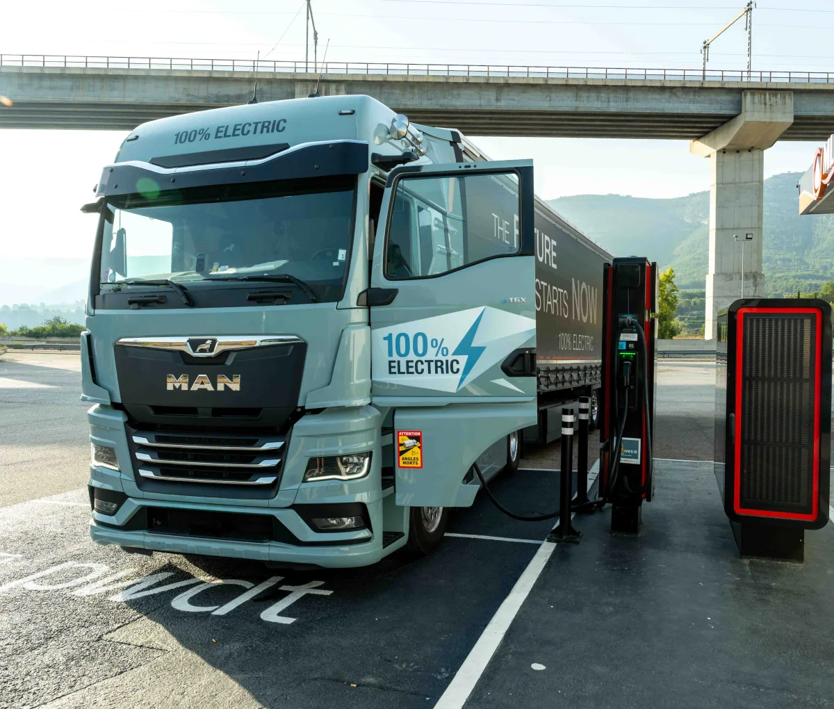 Ein LKW steht auf einem Parkplatz und lädt an einer e-Ladesäule