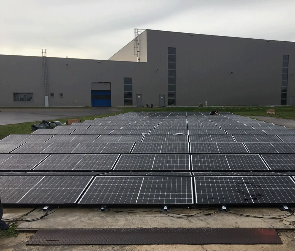 PV Anlage auf einer Freifläche vor einer Industriehalle